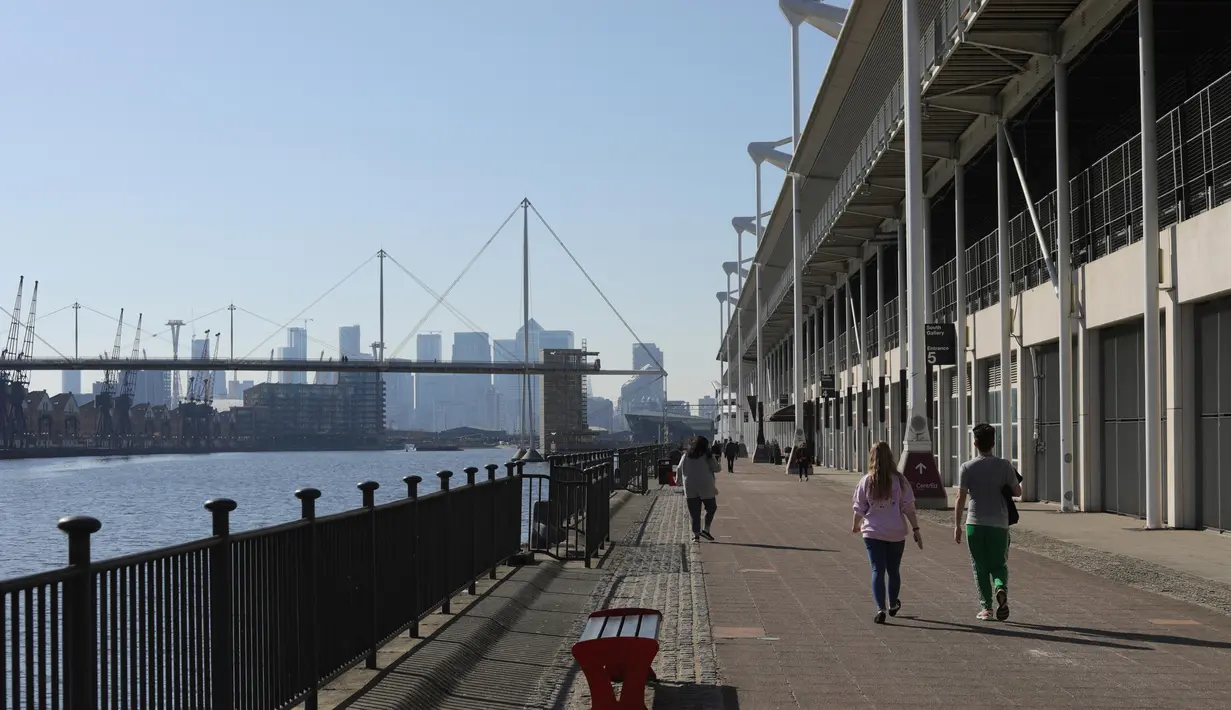 Warga berjalan di luar pusat pameran ExCeL, London, Inggris (25/3/2020). Menkes Inggris Matt Hancock pada Selasa (24/3) mengungkapkan bahwa rumah sakit sementara akan didirikan di gedung ExCeL, sebuah pusat pameran di London timur, dengan kapasitas tampung hingga 4.000 pasien. (Xinhua/Tim Ireland)