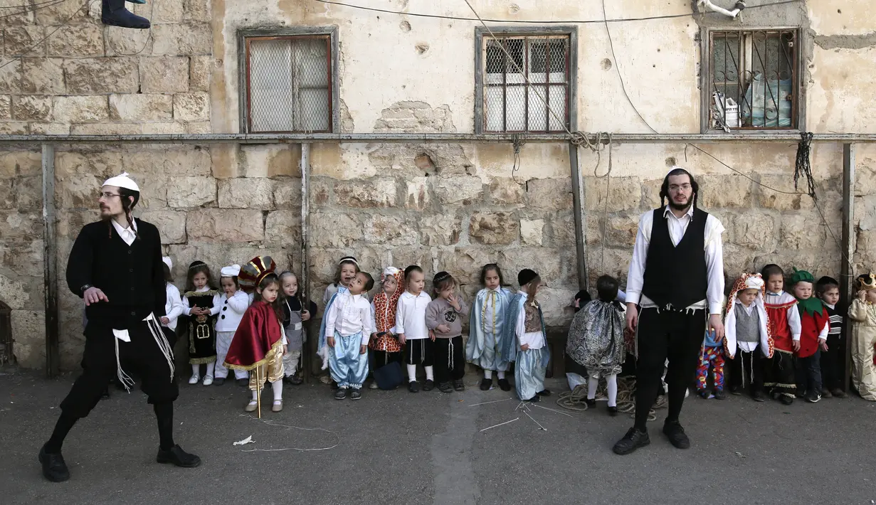 Sejumlah anak-anak Yahudi ultra-Ortodoks mengenakan kostum lengkap dengan atributnya bersiap mengikuti perayaan purim di Yerusalem (8/3). Purim dirayakan tiap tahun menurut kalender Ibrani oleh kaum Yahudi.  (AFP/Menahem Kahana)