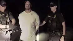 Dalam gambar yang diambil dari video terlihat pegolf ternama AS, Tiger Woods ditangkap dua polisi di Jupiter, Florida, 29 Mei 2017. Tiger Woods harus berurusan dengan pihak kepolisian karena menyetir dalam keadaan mabuk. (Jupiter Police Department/via AP)