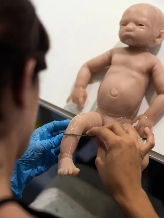 Pekerja menyelesaikan pembuatan boneka bayi silikon yang mirip manusia di Clon Factory, Spanyol Basque, Selasa (20/6). Pabrik ini khusus memproduksi bayi imitasi dari premium silikon yang biasa dipakai untuk operasi plastik. (ANDER GILLENEA/AFP)