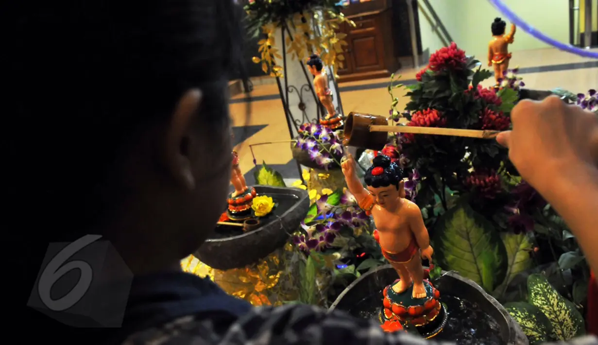 Umat Buddha memandikan patung di taman lumbini (tempat lahirnya sang Buddha) di Vihara Mahira Graha, Jakarta, Senin (1/6/2015). Memandikan patung Budha (Fi Yo) sebagai simbol mensucikan hati dan pikiran bagi umat Buddha.(Liputan6.com/Andrian M Tunay)