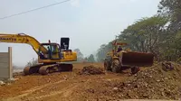 Dua alat berat tengah membuka lahan yang akan dijadikan TPA darurat di dekat area TPA Sarimukti, Kabupaten Bandung Barat, Rabu, 30 Agustus 2023. (Liputan6.com/Dikdik Ripaldi)
