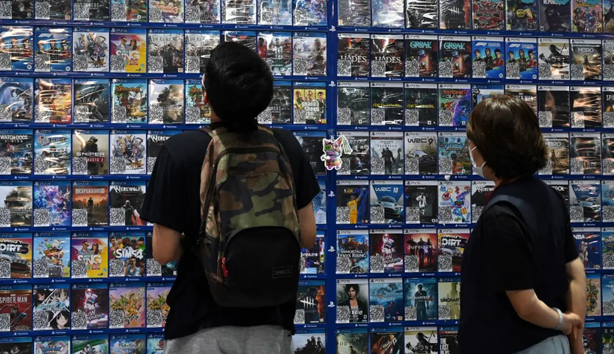 Pelanggan menelusuri game komputer di sebuah toko di Beijing, China, Jumat (10/9/2021). Seorang ayah dari Nanjing, Yan Zhiming mengatakan bahwa pengaturan waktu bermain game online seharusnya adalah tanggung jawab orangtua. (GREG BAKER/AFP)