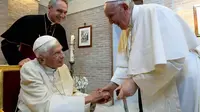 Paus Fransiskus (berdiri) bersama Paus Benediktus XVI (duduk). (Vatican Pool)