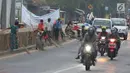 Warga membawa sapu menunggu pengguna jalan memberi sedekah dengan melempar uang di Jembatan Sewo, Jalur Pantura Sukra Indramayu, Jawa Barat, Senin (3/6/2019). Keberadaan pencari sedekah bisa membahayakan keselamatan pemudik serta pengguna jalan lainnya. (Liputan6.com/Herman Zakharia)