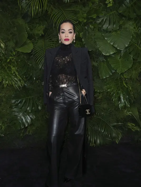 Rita Ora berpose saat tiba di acara makan malam Pre-Oscar Awards ke-14 di Beverly Hills Hotel di Beverly Hills, California pada Sabtu, 11 Maret 2023. Rita Ora 32 tahun mendesis sambil memamerkan fisik pahatannya dalam balutan bodysuit renda hitam tipis dan celana kulit hitam Chanel. Penyanyi ini memadukan penampilannya yang chic dengan blazer wol hitam dan tas beludru Chanel hitam tersampir di bahu kirinya. Cibirannya dicat merah delima dan mata cokelatnya diperkuat dengan eyeliner hitam tebal. (Photo by Jordan Strauss/Invision/AP)