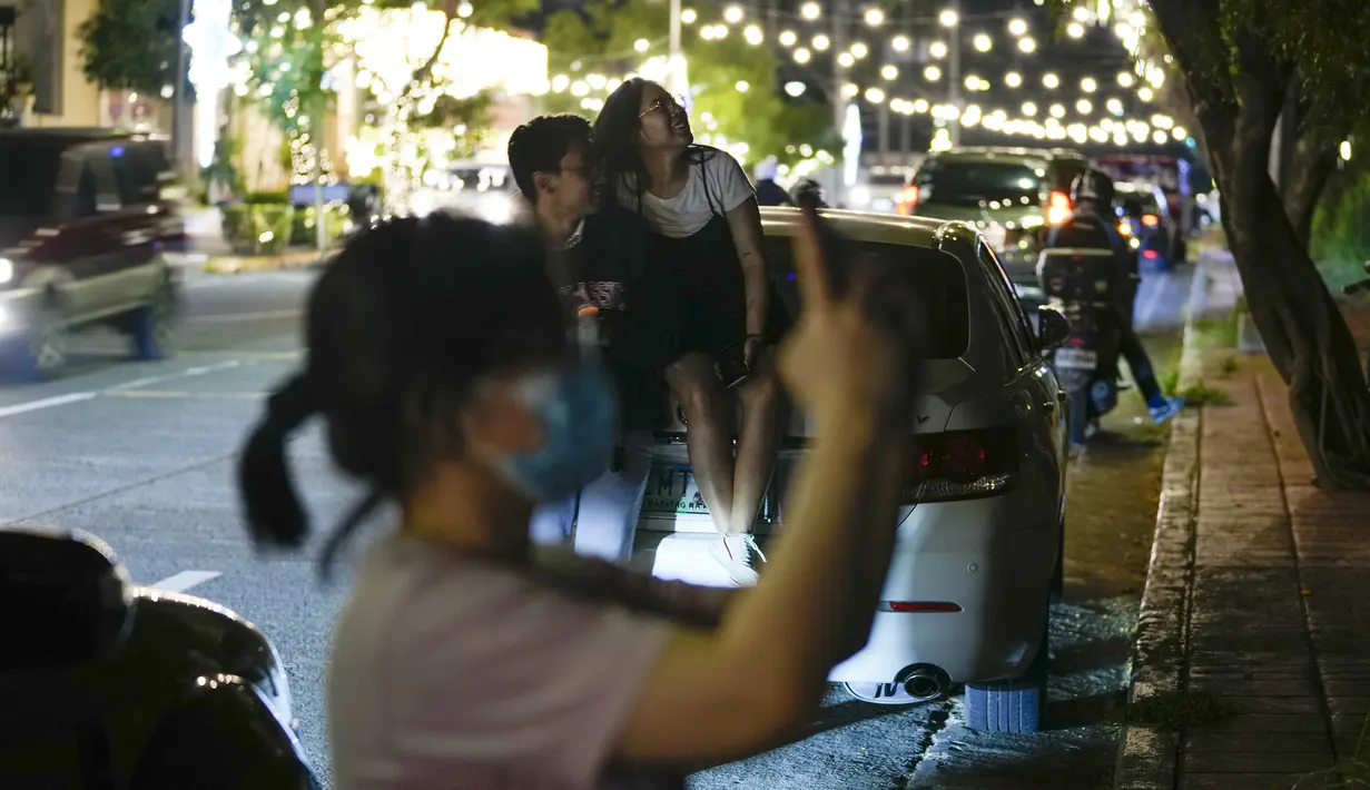 Orang-orang menyaksikan bulan terbit saat gerhana bulan di Metro Manila, Filipina, Selasa, 8 November 2022. fenomena alam tersebut dapat disaksikan dengan mata telanjang. (AP Photo/Aaron Favila)