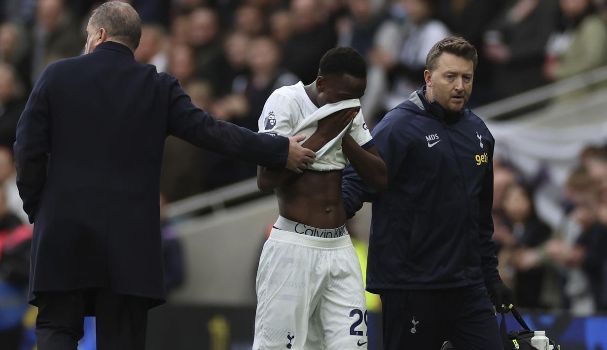 Gelandang Tottenham Hotspur, Pape Matar Sarr berjalan meninggalkan lapangan setelah mengalami cedera saat menghadapi Bournemouth pada laga pekan ke-20 Liga Inggris 2023/2024 di Tottenham Hotspur Stadium, London, Minggu (31/12/2023). (AP Photo/Ian Walton)