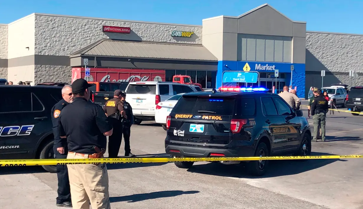 Polisi berjaga setelah penembakan di tempat parkir Walmart, Duncan, Oklahoma, Amerika Serikat, Senin (18/11/2019 ). Pelaku menembak dua orang dalam mobil sebelumnya akhirnya menembak dirinya sendiri. (AP Photo/Sean Murphy)