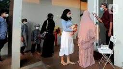 Umat muslim diperiksa suhu tubuhnya saat akan melaksanakan salat Idul Adha 1442 H di Masjid Al-Madina Zona Madina, Parung, Bogor, Jawa Barat, Selasa (20/7/2021). Protokol kesehatan yang dilakukan di antaranya pengecekan suhu tubuh dan pengaturan jarak shaf salat. (merdeka.com/Arie Basuki)
