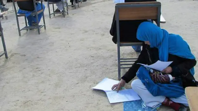 Foto wanita menggendong bayi saat ujian di Afganistan. (AFP)