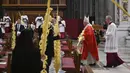 Paus Fransiskus memegang ranting pohon palem saat memimpin Misa Minggu Palma di St. Peter's Basilica, Vatikan, Minggu (5/4/2020). Saat tak ada pandemi virus corona COVID-19 seperti sekarang, perayaan Misa Minggu Palma akan berlangsung ramai. (AP Photo/pool/Alberto Pizzoli)