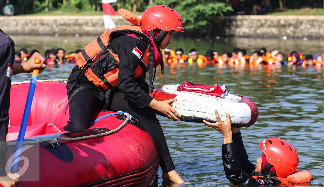 Dua mahasiswa membawa bendera merah putih turun ke dalam Setu Tujuh Muara untuk mengikuti upacara Bendera HUT Kemerdekaan RI ke 71, di Pamulang, Tangerang Selatan, Rabu (17/08). (Liputan6.com/Fery Pradolo)