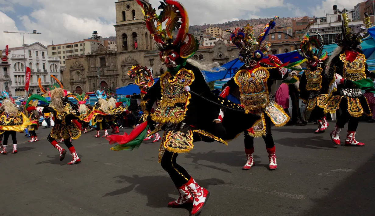 Sejumlah penari mengenakan kostum dan topeng saat parade tahunan untuk menghormati "El Senor del Gran Poder" atau "The Lord of Great Power" di La Paz, Bolivia (10/6). Parade ini juga bentuk terima kasih mereka kepada dewa. (AP Photo / Juan Karita)