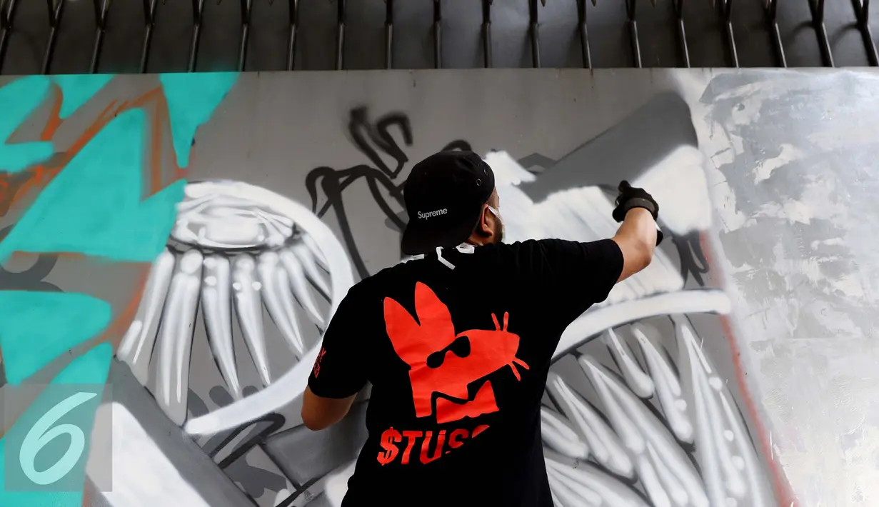 Seorang seniman grafiti sedang berkarya dalam festival Off The Wall di Kawasan Thamrin, Jakarta, Minggu (6/11). Sebanyak 10 Seniman Indonesia dan Prancis berkolaborasi dalam membuat grafiti dengan tema Off The Wall. (Liputan6.com/Gempur M. Surya)