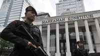Personel kepolisian saat berjaga di depan Gedung Mahkamah Konstitusi (MK), Jakarta, Rabu (26/6/2019). Kepolisian memperketat penjagaan di sekitar Gedung MK dengan kawat berduri, kendaraan lapis baja, serta ratusan personel. (merdeka.com/Iqbal S. Nugroho)