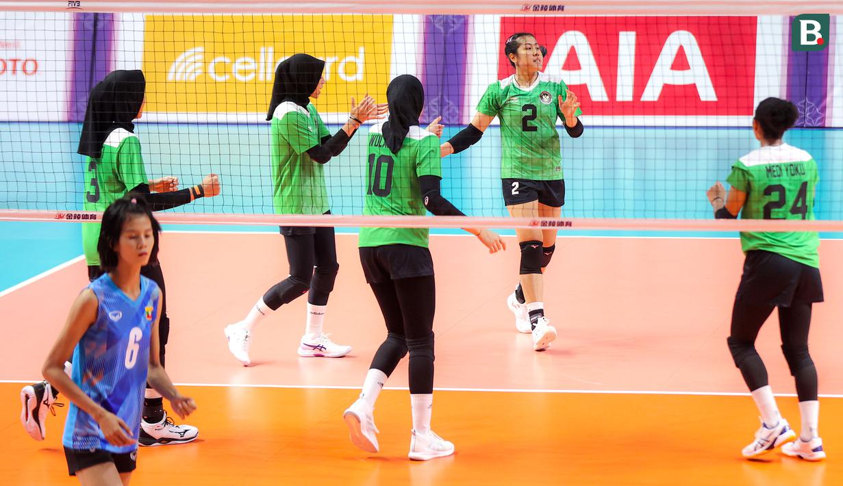 Pemain Timnas Bola Voli Putri Indonesia, Ratri Wulandari melakukan selebrasi bersama rekannya setelah mencetak poin pada laga lanjutan Grup A Bola Voli Putri SEA Games 2023 melawan Myanmar di Olympic Complex Indoor Stadium, Phnom Penh, Kamboja, Kamis (11/5/2023). Ratri berhasil mencetak total 19 poin, dimana sebanyak 13 angkanya ditorehkan melalui situasi bola servis. (Bola.com/Abdul Aziz)