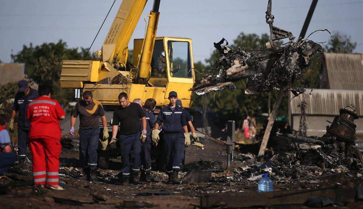 Beberapa anggota Kementerian Darurat Ukraina, tenaga medis serta operator alat berat bekerja diantara puing-puing pesawat Malaysia Airlines MH-17 yang jatuh di desa Hrabove, Donetsk, Ukraina, (20/7/2014). (REUTERS/Maxim Zmeyev) 