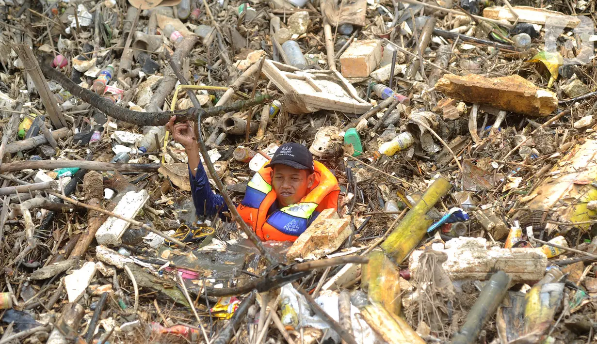 Petugas gabungan membersihkan tumpukan sampah yang menyumbat aliran air Sungai Cikeas di kawasan Bendung Koja Jatiasih, Bekasi, Jawa Barat, Rabu (16/10/2019). Pembersihan sekitar 1.200 meter kubik sampah bambu tersebut diperkirakan menghabiskan waktu dua minggu. (merdeka.com/Arie Basuki)