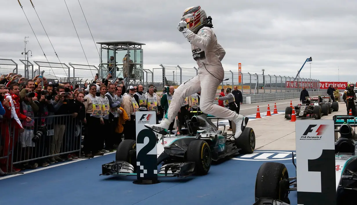 Pembalap Mercedes, Lewis Hamilton melompat usai memenangkan Grand Prix F1 Amerika Serikat di Sirkuit The Americas, Minggu (25/10). Ini merupakan gelar juara dunia ketiga bagi Hamilton setelah sebelumnya diraih pada 2008 dan 2014. (REUTERS/Adrees Latif)