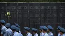 Beberapa anggota militer melintasi monumen yang bertuliskan nama-nama orang yang gugur dalam pertempuran melawan Jepang selama Perang Dunia II di Aviation Martir Memorial di Nanjing, (3/9/2014). (AFP PHOTO/STR)