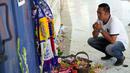 Seorang pria berdoa untuk para korban kerusuhan di depan Gerbang 13, Stadion Kanjuruhan, Malang, Selasa (4/10/2022). Polri menjatuhkan sanksi kepada 10 anggota polisi dan menyelidiki 18 orang lainnya buntut tragedi kerusuhan yang menewaskan 125 orang di Stadion Kanjuruhan. (AP Photo/Achmad Ibrahim)