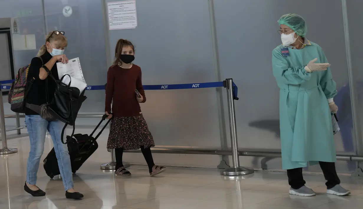 Seorang pekerja hotel memandu turis yang tiba di Bandara Internasional Suvarnabhumi di Bangkok, Thailand, Senin (1/11/2021). Thailand mulai Senin ini telah dibuka kembali untuk wisatawan mancanegara yang divaksinasi penuh tanpa perlu menjalani proses karantina Covid-19. (AP Photo/Sakchai Lalit)