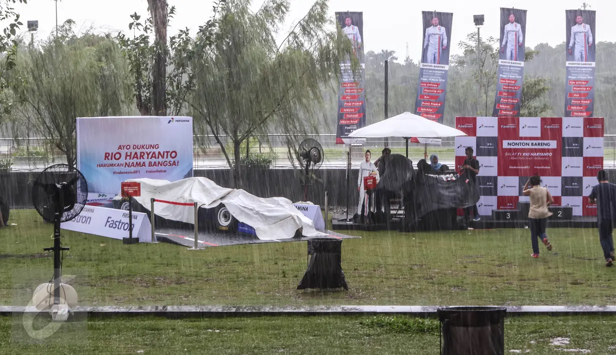 Penonton berlari akibat hujan deras mengguyur arena acara Nonton Bareng F1 GP Australia 2016 Pertamina di Mall Bintaro Xchange, Tangerang Selatan, Minggu (20/3). Acara tersebut terbuka untuk umum, termasuk fans Rio Haryanto. (Liputan6.com/Fery Pradolo)