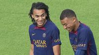 Pemain Paris Saint-Germain (PSG), Kylian Mbappe, berbincang dengan Ethan Mbappe saat sesi latihan di Poissy, Paris, Jumat (18/8/2023). Mbappe mengikuti latihan dan diperkirakan akan tampil melawan Toulouse pada pekan kedua Liga Perancis 2023-2024. (AP Photo/Michel Euler)