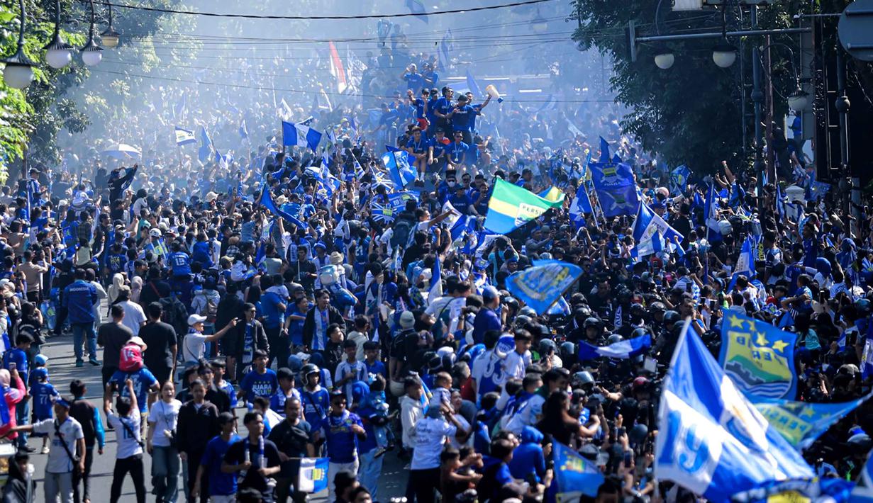 Warga menyambut tim dan ofisial Persib Bandung saat pawai perayaan gelar juara BRI Super League 2025/2026 di Bandung, Jawa Barat, Minggu (24/5/2026). (Bola.com/Bagaskara Lazuardi)