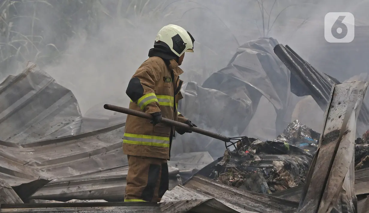 Petugas pemadam kebakaran melakukan pendingin di Pabrik penggilingan kapas,  Pasar Rebo, Jakarta Timur, Selasa (16/11/2021). Api melalap Pabrik penggilingan kapas yang di sebabkan korsleting pada panel listrik. (Liputan6.com/Herman Zakharia)