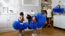 Milli Astill (7) menghibur Lissi-Lu (3) saat bersiap melakukan sesi foto dengan seragam balet berwarna biru khas tim Leicester City di Leicester, Inggris, (22/4/2016). (Reuters/Darren Staples)