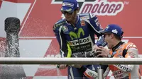 Marc Marquez dan Valentino Rossi saling semprot sampanye di podium juara MotoGP Argentina di Sirkuit Autodromo Termas de Rio Hondo, Senin (4/4/2016) dini hari WIB. (AFP/Juan Mabromata))