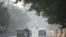 Kendaraan berjalan di sepanjang jalan di tengah kondisi kabut asap tebal di New Delhi (15/11/2021). Otoritas kota New Delhi tengah mempertimbangkan penguncian wilayah akibat kian memburuknya polusi udara. (AFP/Money Sharma)