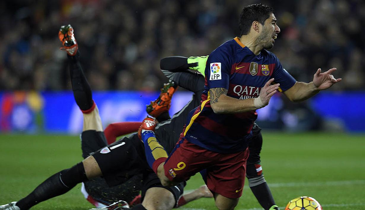 Striker Barcelona, Luis Suarez, terjatuh ditarik kiper Athletic Bilbao, Gorka Iraizoz. Berkat kemenangan itu Barca berhasil kembali ke posisi dua klasemen La Liga. (AFP/Lluis Gene)