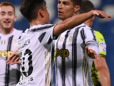 Striker Juventus, Cristiano Ronaldo (kanan) melakukan selebrasi usai mencetak gol kedua timnya ke gawang Sassuolo dalam laga lanjutan Liga Italia 2020/2021 pekan ke-36 di Mapei-Citta del Tricolore Stadium, Rabu (12/5/2021). Juventus menang 3-1 atas Sassuolo. (AFP/Marco Bertorello)