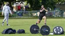 Seorang trainer menyaksikan anggota fitness berolahraga di sebuah taman di pinggiran timur Sydney, pada 14 September 2021. Pelatih pribadi telah mengubah taman kawasan tepi laut di Rushcutters Bay menjadi gym luar ruangan untuk menyiasati pembatasan lockdown karena pandemi covid-19. (AP/Mark Baker)