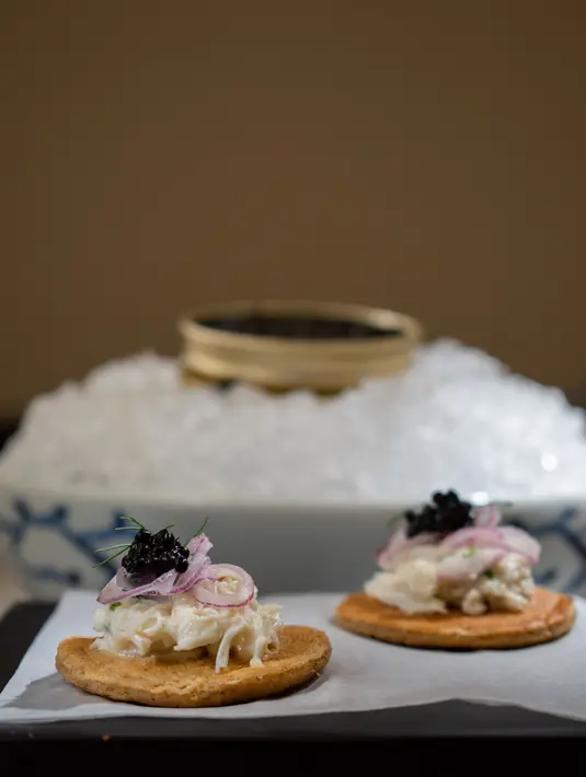 Untuk kamu penyuka vaciar, jangan lewatkan menu yang satu ini. Amuse Bouche yang terdiri dari taburan caviar, daging kepiting dan blinis. Letupan caviar yang bertemu dengan lembutnya suwiran daging kepiting berpadu apik di lidah. / Foto dok: Park Hyatt Jakarta.