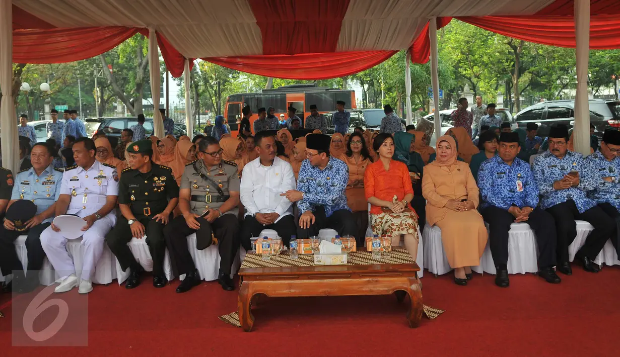 Gubernur DKI Basuki T Purnama (tengah) bersama istrinya, Veronica Tan menghadiri upacara peringatan Hari Pahlawan di lapangan eks IRTI Monas, Jakarta, Selasa (10/11). Upacara itu diikuti  para PNS di lingkungan Pemprov DKI. (Liputan6.com/Gempur M Surya)