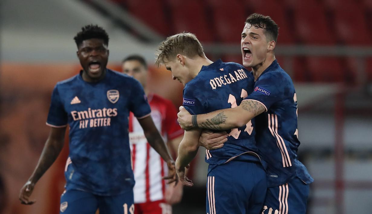 Striker Arsenal, Martin Odegaard (kedua dari kanan) melakukan selebrasi usai mencetak gol pertama timnya ke gawang Olympiakos dalam laga leg pertama babak 16 besar Liga Europa 2020/2021 di Georgios Karaiskakis Stadium, Kamis (11/3/2021). Arsenal menang 3-1 atas Olympiakos. (AP/Thanassis Stavrakis)
