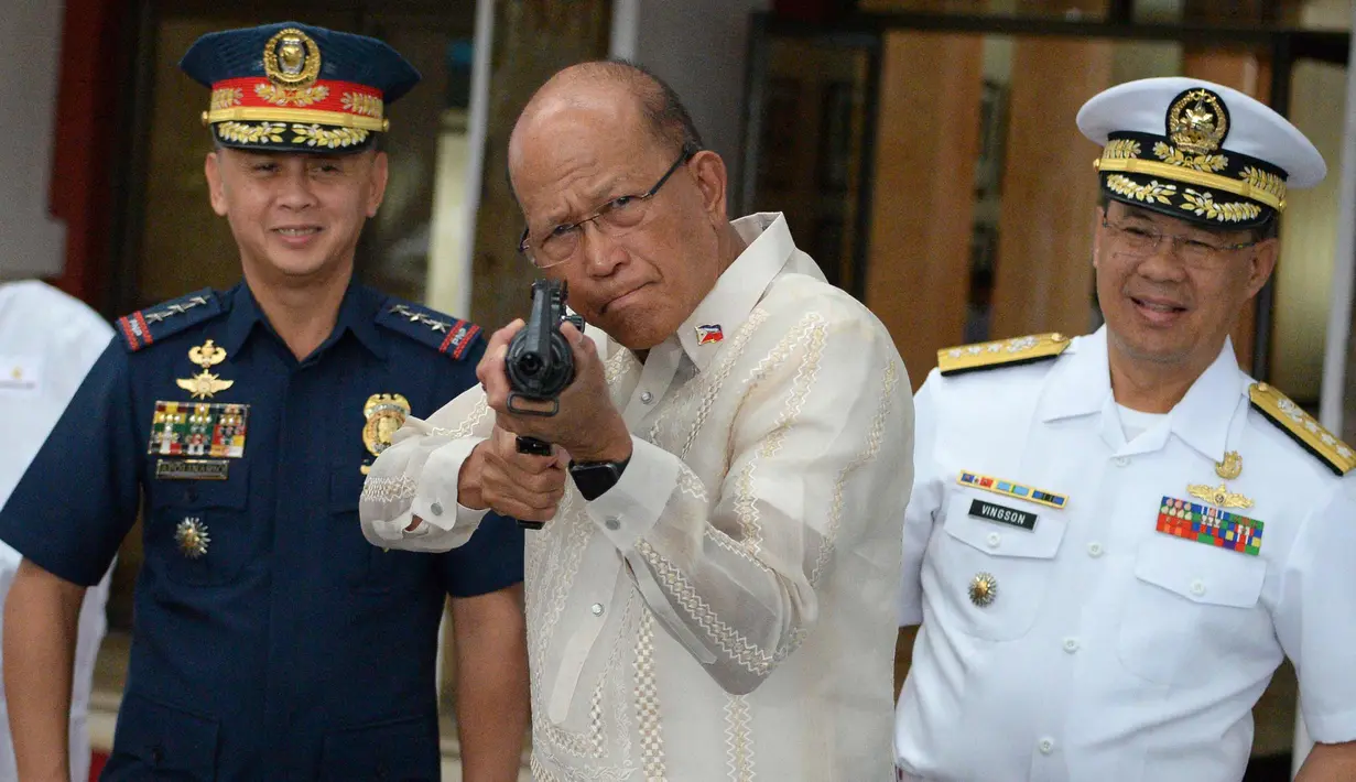 Menhan Filipina Delfin Lorenzana mencoba senapan serbu yang dihibahkan China, Manila, Filipina (5/10). Ribuan senapan serbu senilai US$ 3,3 juta (Rp 43,7 miliar) akan diserahkan seluruhnya ke Kepolisian Nasional Filipina (PNP). (AFP Photo/Ted Aljibe)