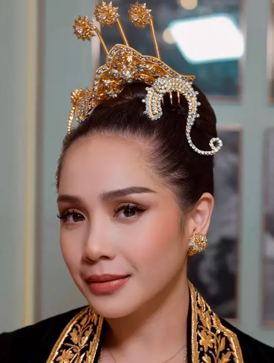 Wajahnya juga tampak dikontur halus, ditambah aplikasi bronzer coklat muda yang beri efek rona kulit hangat. Kemudian pipinya diaplikasikan blush on warna coral yang segar. [@raffinagita1717/@erniaredberry]