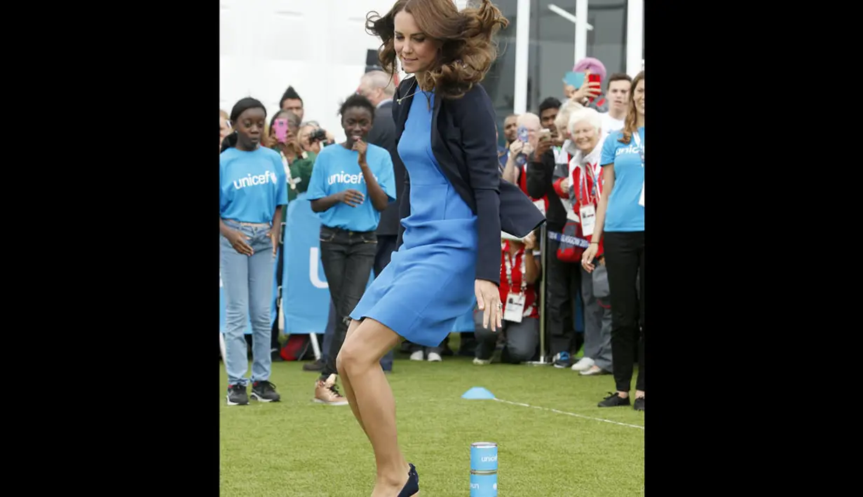Tanpa ragu, Duchess of Cambridge, Kate Middleton, melompat saat memainkan permainan asli Afrika Selatan "Tiga Kaleng" di Commonwealth Games Village di Glasgow, Skotlandia, (29/7/2014). (REUTERS/Danny Lawson)