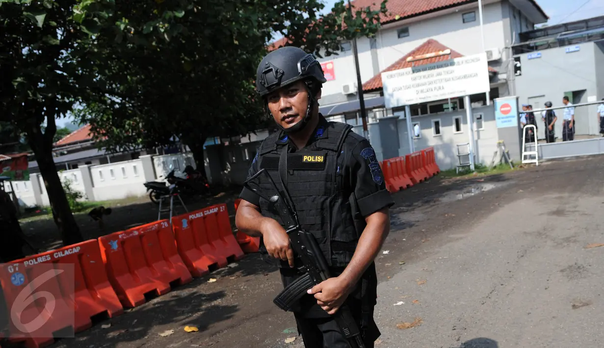 Polisi bersenjata laras panjang berjaga di dekat pintu masuk dermaga Wijayapura menuju LP Nusakambangan, Cilacap, Jateng, Kamis (28/7). 1.466 personel gabungan disiagakan untuk melakukan pengamanan eksekusi mati tahap III. (Liputan6.com/Helmi Afandi)