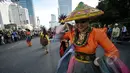 Sejumlah warga menyaksikan Aksi menari Mahasiswa saat car free day di Bundara HI, Jakarta, Minggu (26/4/2015). Mereka meminta sumbangan kepada warga untuk mengikuti Interntional Folklore Festival di Spanyol. (Liputan6.com/Faizal Fanani)