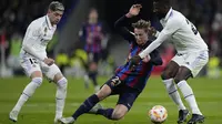 Pemain Barcelona, Frenkie de Jong (tengah) berebut bola dengan pemain Real Madrid, Antonio Rudiger (kanan) dan Federico Valverde pada laga leg pertama semifinal Copa Del Rey 2022/2023 di Santiago Bernabeu, Madrid, Jumat (03/03/2023) WIB. Laga berakhir dengan skor 1-0 untuk kemenangan Barcelona. (AP Photo/Bernat Armangue)