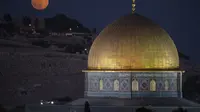 Bulan purnama terbesar atau supermoon terbit di balik kuil Dome of the Rock di kompleks Masjid Al Aqsa di Kota Tua Yerusalem, Senin, 19 Agustus 2024. (AP Photo/Leo Correa)