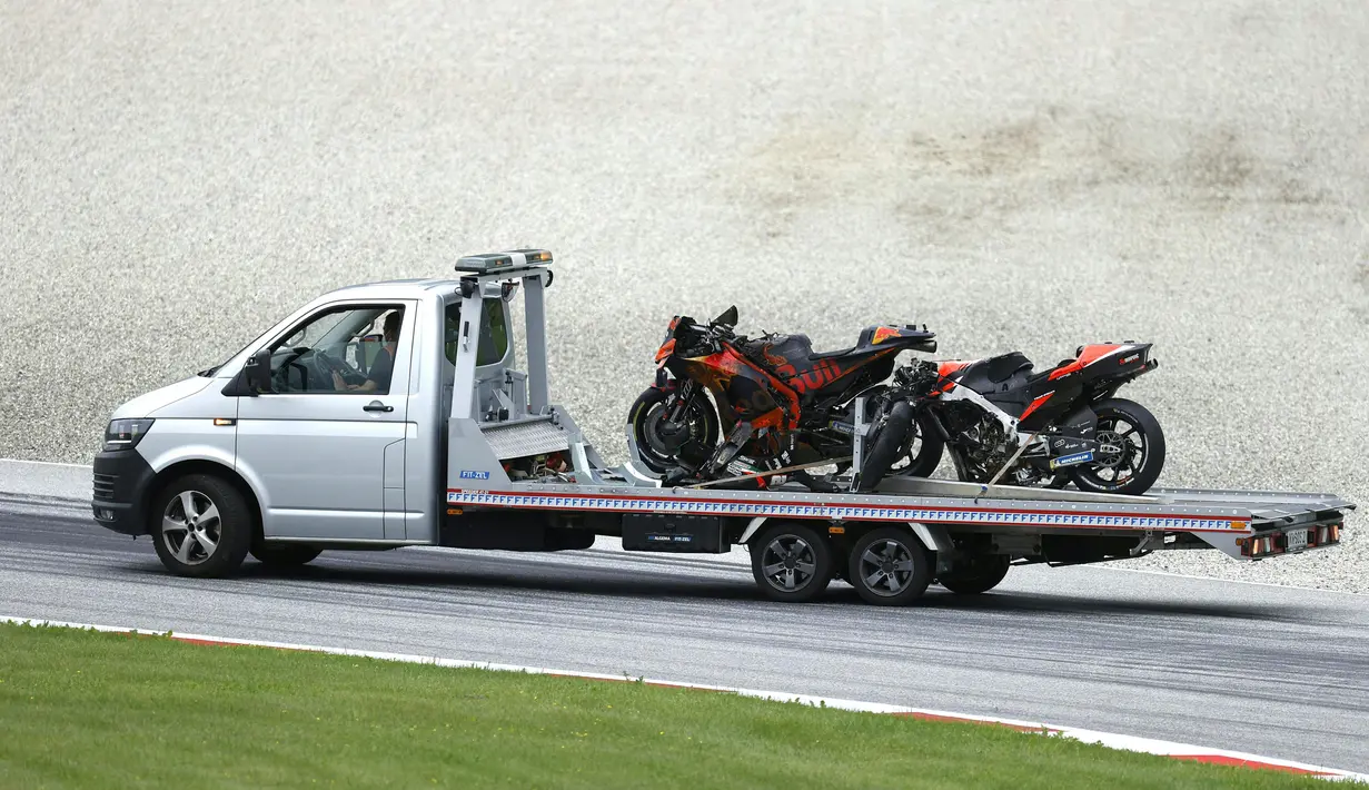 Motor pembalap Aprilia Gresini, Lorenzo Savadori dan pembalap KTM, Dani Pedrosa diangkut dari trek menyusul kecelakaan saat MotoGP Styria 2021 di Red Bull Ring, Minggu (8/8/2021). Peristiwa ini kali ketiga secara beruntun balapan MotoGP di Red Bull Ring harus dihentikan. (ERWIN SCHERIAU/APA/AFP)