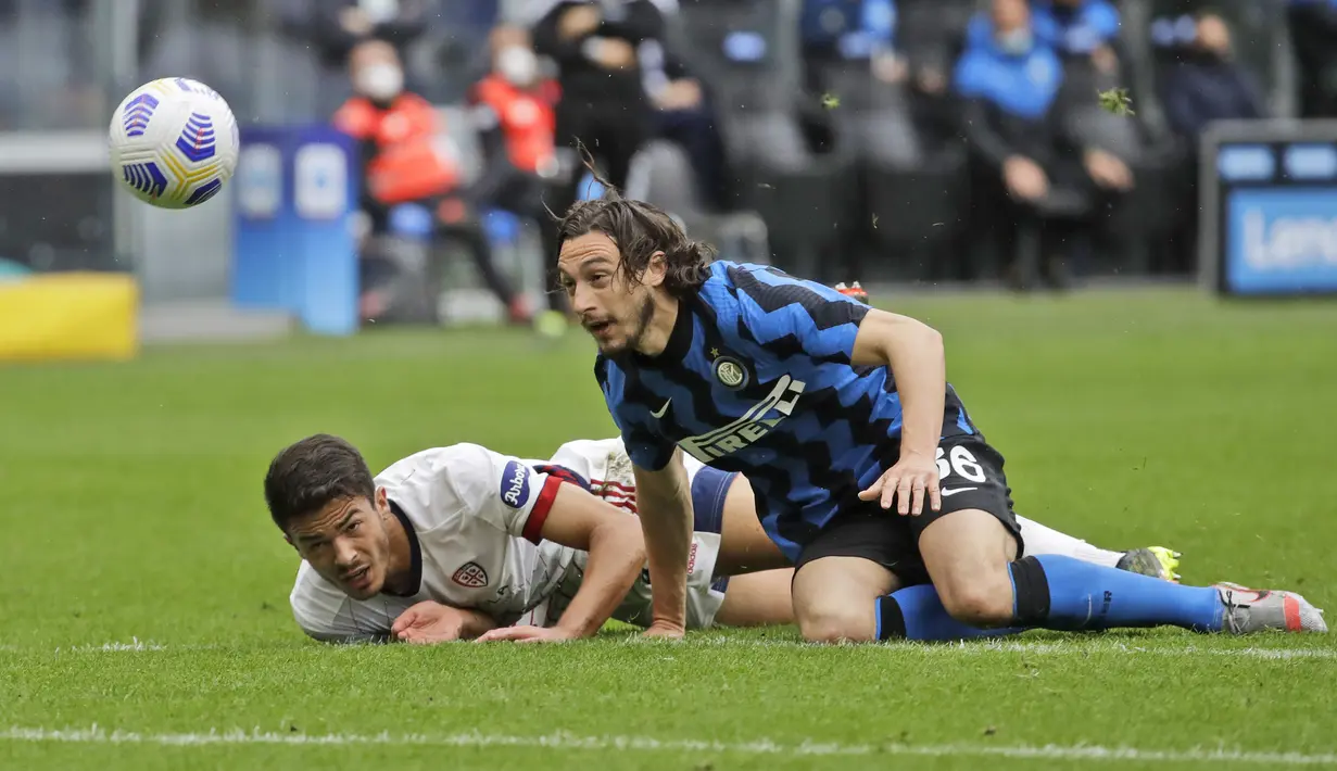 Bek Inter Milan, Matteo Darmian (kanan) dan bek Cagliari, Andrea Carboni terjatuh saat perebutan bola dalam laga lanjutan Liga Italia 2020/2021 pekan ke-30 di San Siro Stadium, Milan, Minggu (11/4/2021). Inter Milan menang 1-0 atas Cagliari. (AP/Luca Bruno)