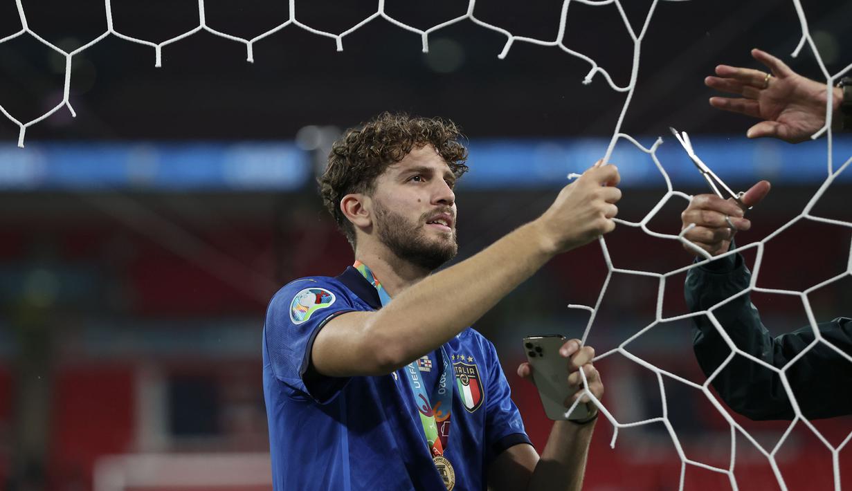 Berbeda dengan lainnya, Manuel Locatelli tampak melakukan pemotongan jaring tak seorang diri. Ia dibantu rekannya menggunting, sementara dirinya memegangi jaring yang akan menjadi bagiannya. (Foto: AP/Pool/Carl Recine)